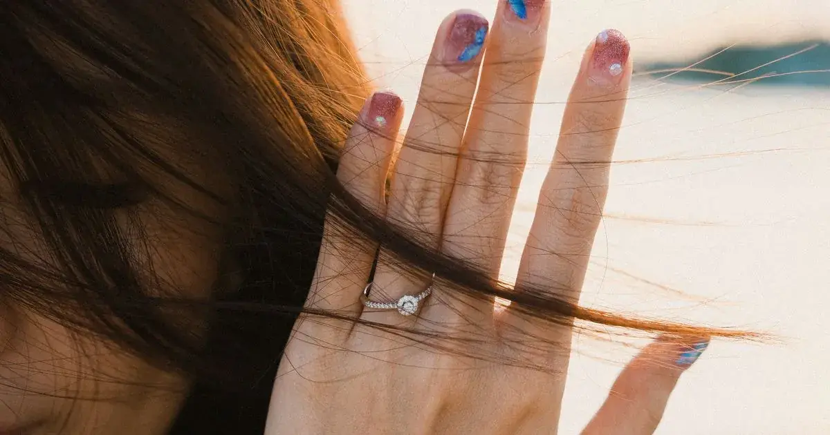 Close-up of a hand with colourful nail art and a sparkling ring, the kind of finish covered in how to edit holographic nail photos