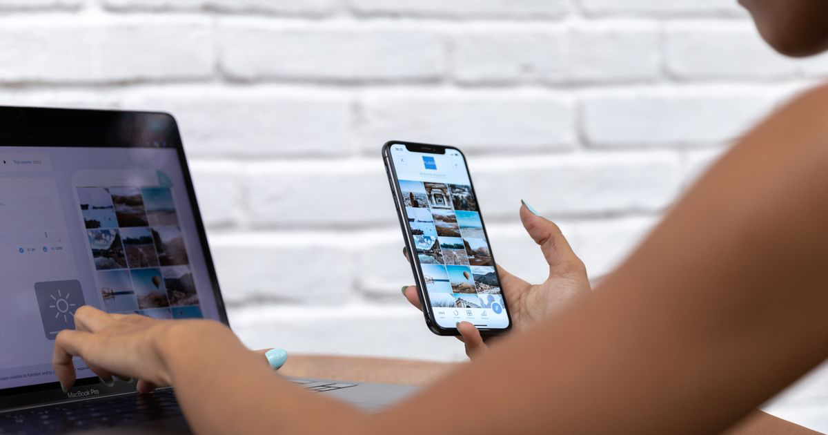 Choosing a nail photo editing app on a smartphone beside a laptop showing photos