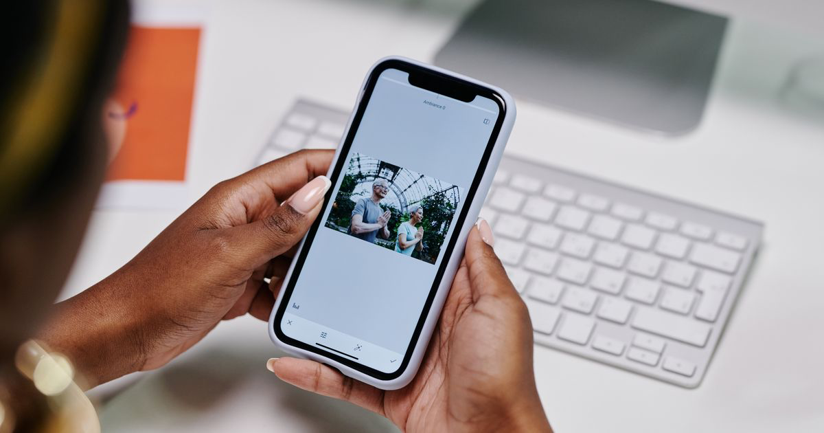 A person holding a smartphone and scrolling a photo gallery, the starting point for editing nail photos in Google Photos
