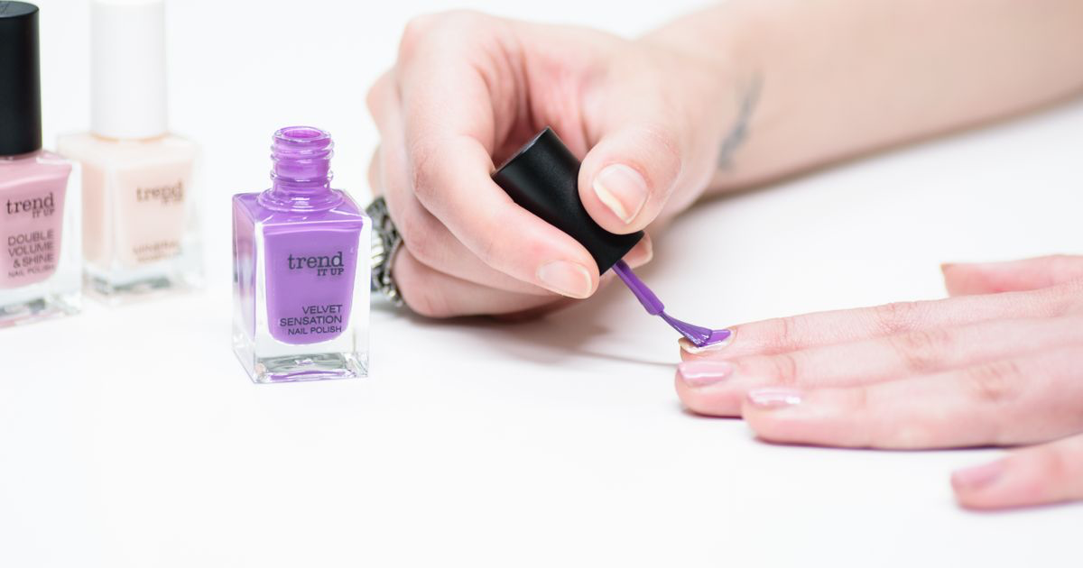 A close-up of soft purple polish being applied during a manicure, the kind of gradient shade that needs careful editing on aura nail photos
