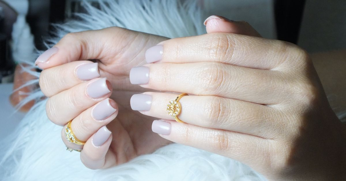 Close-up of hands with a soft nude squoval overlay manicure and a gold ring, the kind of BIAB set whose apex and cuticle line need careful editing