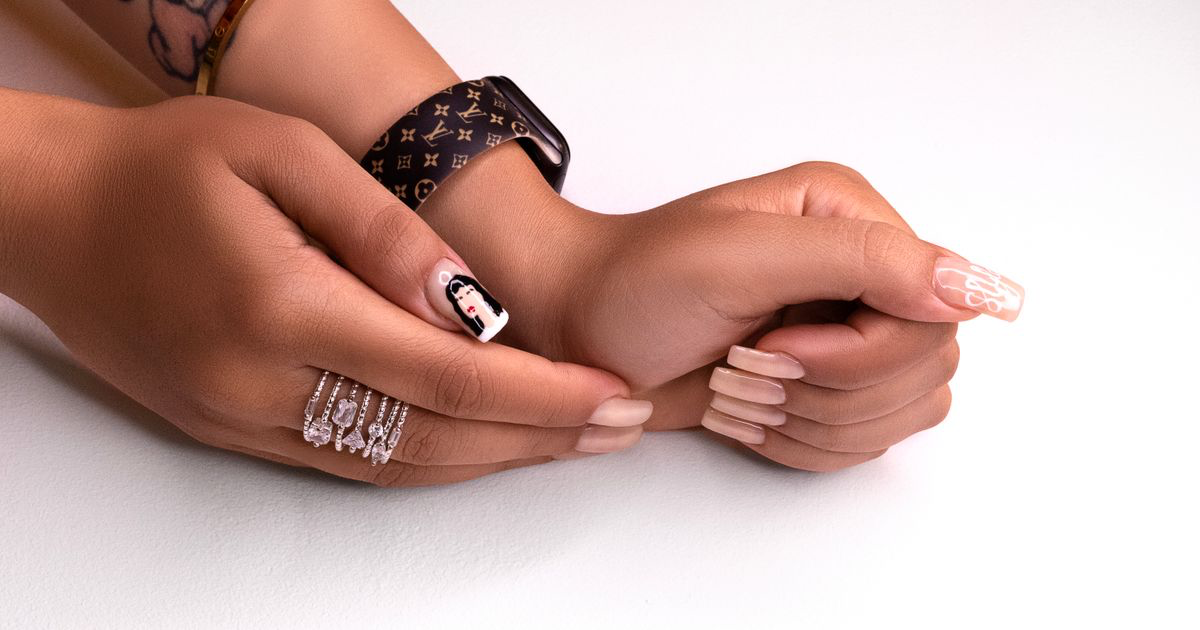 Hands with a nude manicure and nail art resting on a plain white background, the kind of nail photo edited with a background removal app like Photoroom